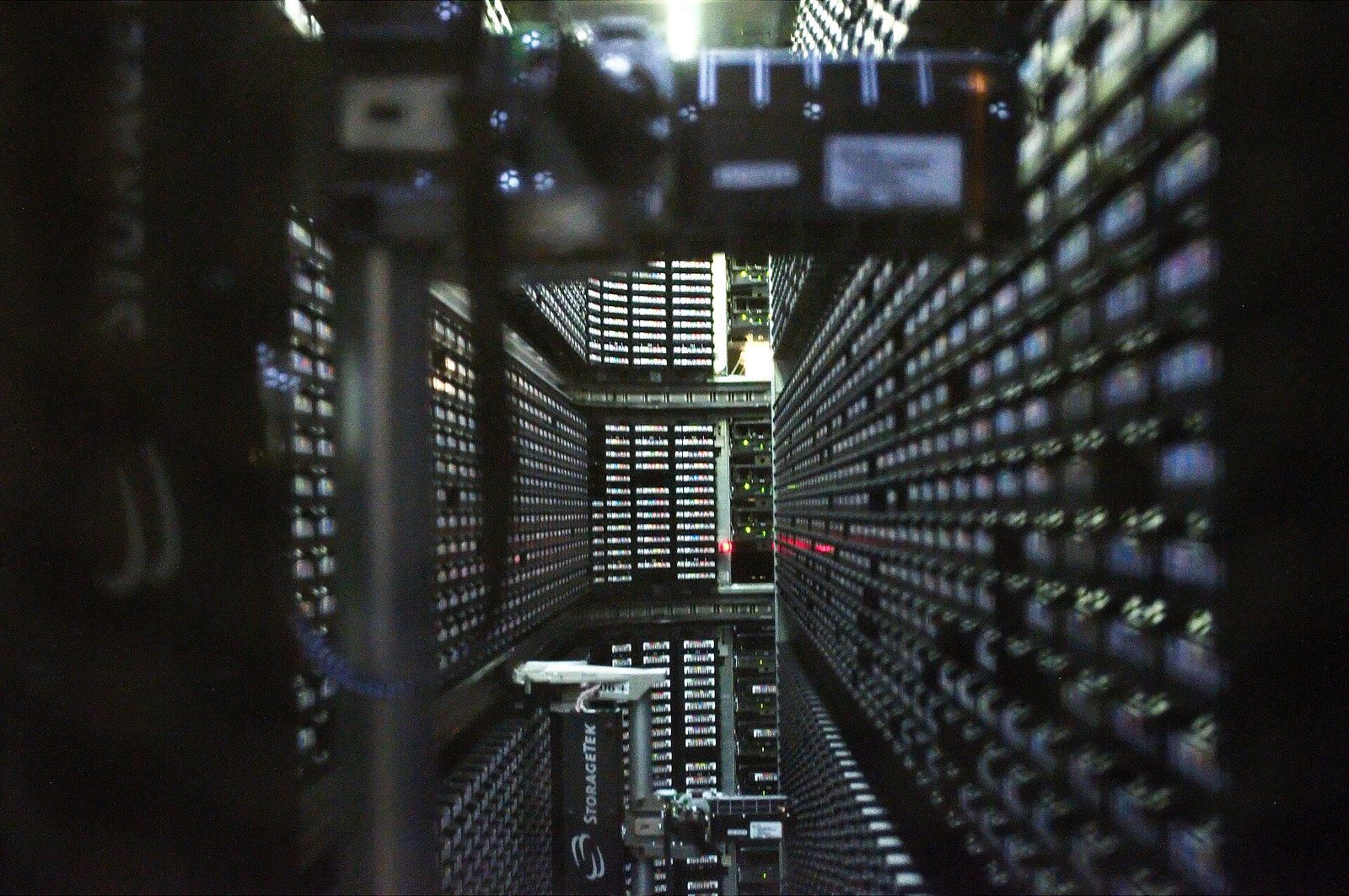 Looking down the aisle inside a robotic StorageTek tape library, with walls of tape cartridges on both sides