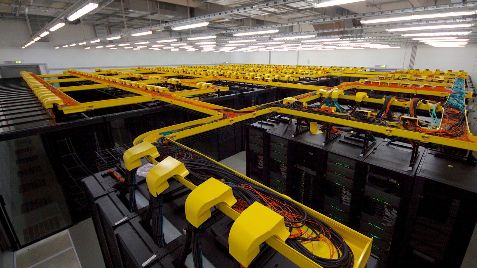 Top-down view of the SuperMUC supercomputer at the Leibniz Supercomputing Centre with yellow cable trays over the racks
