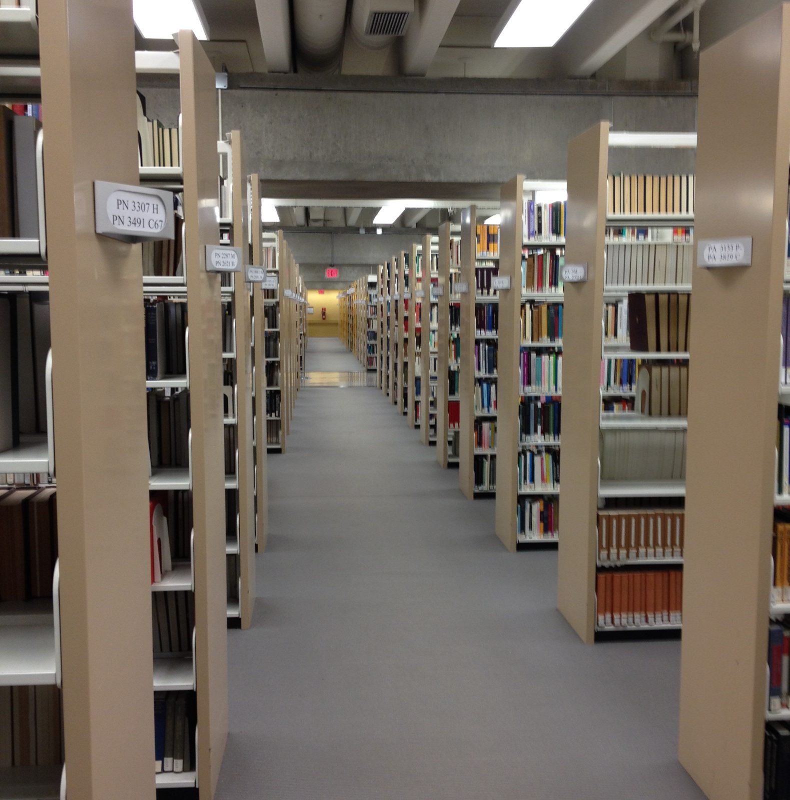 A long aisle of library shelves receding into the distance
